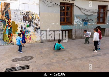 Les enfants jouent au futbol dans les rues de Valence, en Espagne. Banque D'Images