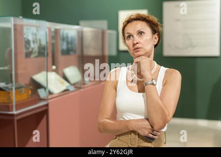Femme d'âge moyen regardant les expositions dans le musée historique Banque D'Images