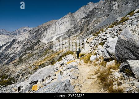 Un randonneur marchant sur High Sierra Trail sur le flanc de la montagne rocheuse. Banque D'Images