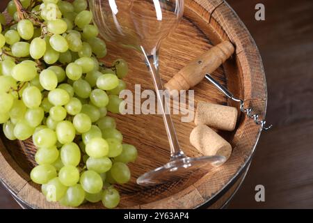 Tire-bouchon, verre, bouchons, raisins et tonneau en bois sur table, gros plan Banque D'Images