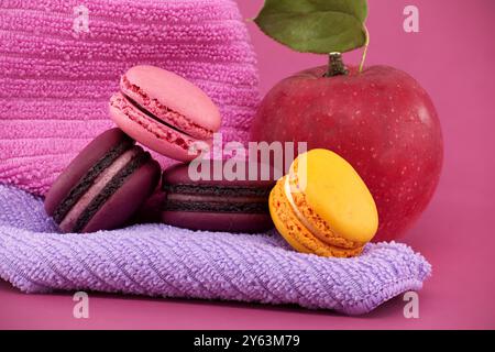 Scène vibrante de fruits et de macarons à base de meringue sucrée sur un fond rose Banque D'Images