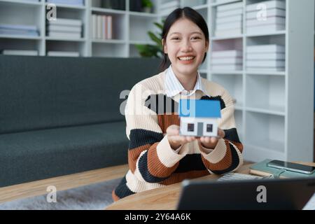 femme conçoit un plan d'épargne financière axé sur la garantie d'un prêt résidentiel, en gérant soigneusement son budget pour atteindre l'accession à la propriété et la fin à long terme Banque D'Images