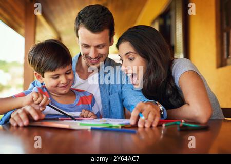 Dessin, excité et devoirs avec la famille à table pour l'éducation, le soutien et le projet scolaire. Apprentissage, connaissance et développement des leçons avec les parents Banque D'Images