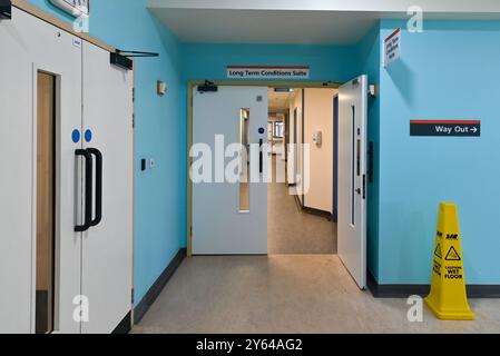 Couloir vide à l'intérieur d'un hôpital du NHS avec une porte coupe-feu ouverte. Septembre 2024. Banque D'Images