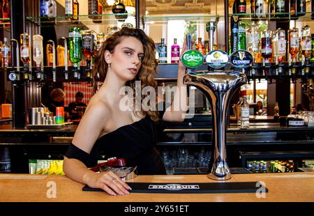 Ava Nicholson, une belle mannequin, pose pour une photographie derrière le bar à l’intérieur de l’hôtel Dundee Queens en Écosse Banque D'Images