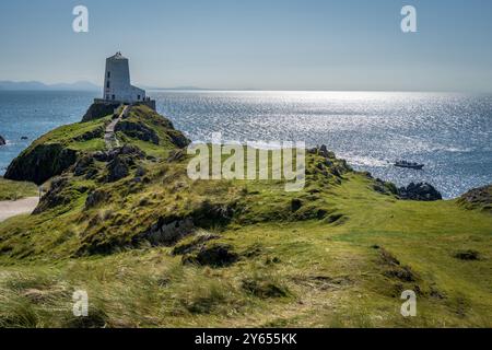 Île de Llanddwyn. Phare de Goleudy Tŵr Mawr contre une mer argentée étincelante. Banque D'Images