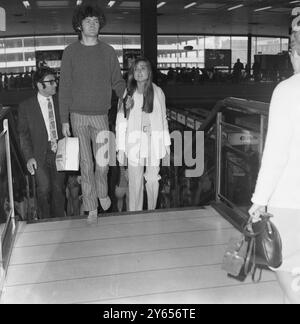 Micky Dollenz du groupe pop américain, les Monkees, quitte l'aéroport de Londres avec sa petite amie Samantha juste pour Los Angeles . Il a été en Angleterre pour une visite privée. Samantha est devenue bien connue comme la fille qui a placé les disques sur la table tournante dans une émission pop télévisée britannique.4 juin 1968 Banque D'Images