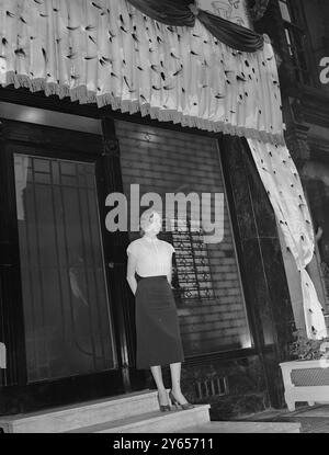 Avant - Row Coronation Seat Her Prize. Londres ; ' Miss Afrique du Sud ' est une blonde aux cheveux Ingrid Rita Mills , 20 ans sténographe dactylographe . Pour gagner le titre dans une nation - large compétition Ingrid obtient , dans le cadre de son prix , un siège avant au couronnement . Elle a apporté avec ses cadeaux d'oranges des enfants de sa maison - ville , Port Elizabeth , pour le Prince Charles et la Princesse Anne . Photos : la charmante Miss Afrique du Sud posant devant quelques balustrades parsemées de guirlande . 30 mai 1953 Banque D'Images