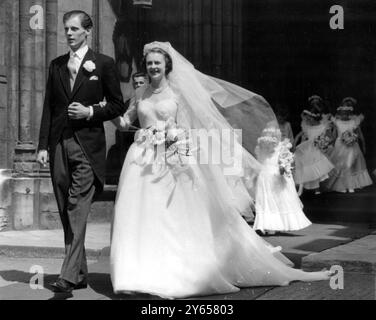 Dans une robe crinoline en tulle blanc Lady Caroline Montagu Douglas Scott quitte sa maison londonienne pour son mariage à l'abbaye de Westminster avec M. Ian Hedworth Gilmour, fils de Sir John Gilmour. Lady Caroline , fille de 23 ans du duc et de la duchesse de Buccleuch , est la quatrième des demoiselles d'honneur de la princesse Élisabeth à se marier. Vu ici marié et marié quittant l'abbaye de Westminster après la cérémonie. Prince Richard de Gloucester était une page . 10 juillet 1951 Banque D'Images