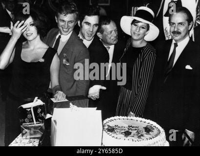 Fête d'anniversaire surprise pour Anthony Newley. Les célébrants voient un gâteau d'anniversaire géant lors d'une soirée surprise dans une boîte de nuit New-yorkaise hier soir qui a marqué le 34e anniversaire de la star britannique Anthony Newley . Il a également marqué la vingtième année dans le show business de M. Newley , qui joue dans The Roar of the Greasepaint et The Smell of the Crowd , une production de Broadway . De gauche à droite sont l'actrice Joan Collins , épouse de Newley ; Tommy Steele ; Newley ; Julie Stein ; Barbra Strreisand et David Merrick 25 septembre 1965 Banque D'Images