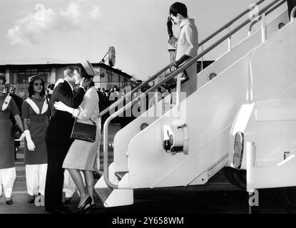 La première dame de l'Amérique , Mme Jacqueline Kennedy , épouse du président , embrasse son beau-frère le prince Radziwill , qui à son tour embrasse la sœur de sa femme après qu'elle ait quitté l'avion de ligne Boeing dans lequel elle et la princesse Lee Radziwill avaient volé de Karachi après leur tournée en Inde et au Pakistan . Mme Kennedy est arrivée pour une visite privée de trois jours à Londres au cours de laquelle elle déjeunera avec la reine Elizabeth. 26 mars 1962 Banque D'Images