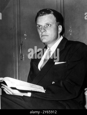 L'évangéliste américain Billy Graham tient une Bible et médite avant de conduire un rassemblement au Madison Square Garden , New York le 7 mars 1955 Banque D'Images