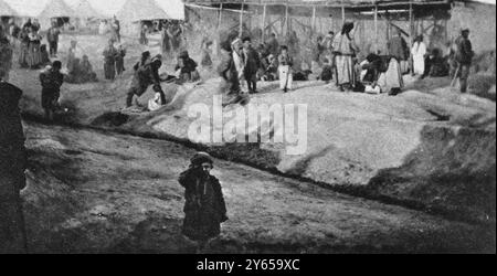 Réfugiés syriens et arméniens : Camp de Ba'qubah , près de Bagdad , Irak , organisé par les Britanniques , une vue d'un de leurs abris , avec un petit garçon saluant . 7 juin 1919 Banque D'Images