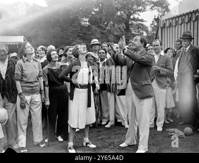 Auteurs v actrices au cricket Une équipe d'auteurs dirigée par Mr J B Priestley et une équipe d'actrices dirigée par Miss Gladys Cooper , se sont rencontrées dans un match de cricket pour aider la St Pancras House Improvement Society dans le magnifique terrain de la maison de Mme Clarence Gasque à Hampstead, Londres. Miss Gladys Cooper et Mr J B Priestley jetant vers le haut avant le début de la partie . 14 juillet 1932 Banque D'Images