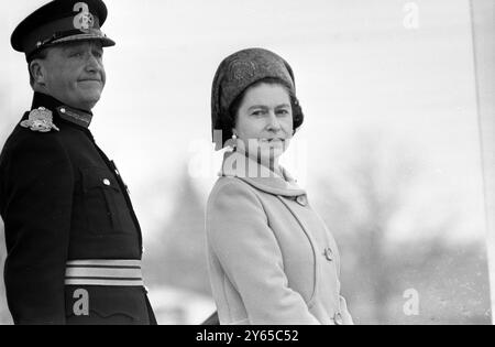 Il faisait plutôt froid sur le terrain de défilé de Woolwich ce matin, mais sa Majesté la Reine a réussi à ne pas avoir l'air trop froid en examinant son Royal Regiment of Artillery. Sa Majesté , capitaine-général de l'artillerie royale , est accompagnée sur la base de salutation par le maître artilleur St James's Park , le général Sir Robert Mansergh . 27 mars 1969 Banque D'Images