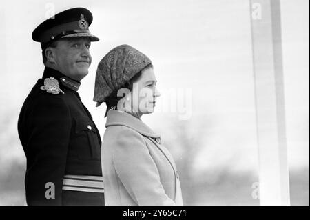 Il faisait plutôt froid sur le terrain de défilé de Woolwich ce matin, mais sa Majesté la Reine a réussi à ne pas avoir l'air trop froid en examinant son Royal Regiment of Artillery. Sa Majesté , capitaine-général de l'artillerie royale , est accompagnée sur la base de salutation par le maître artilleur St James's Park , le général Sir Robert Mansergh . 27 mars 1969 Banque D'Images