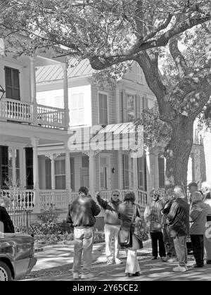 Groupe de touristes écoutant un guide tout en regardant des maisons historiques sur Cabbage Row sur Church Street à Charleston, Caroline du Sud, États-Unis. Banque D'Images