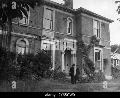 Le corps d'une veuve de 89 ans , Mme Minnie Freeman-Lee , a été retrouvé coincé dans un coffre lorsque la police a pénétré de force dans sa maison de 22 pièces Winford , Ray Park Avenue , Maidenhead , Berks . On pense que Mme Lee est morte le week-end dernier . La découverte whave a été collectée . La maison avait été saccagée et les agents du CID avaient recueilli les déclarations de plusieurs personnes pour établir si Mme Lee possédait ou non , comme on le lui disait , une grande quantité de bijoux . Photos : un policier et une policière vus debout devant la maison de 22 pièces à Ray Park Avenue , Maidenhead peu après la découverte Banque D'Images