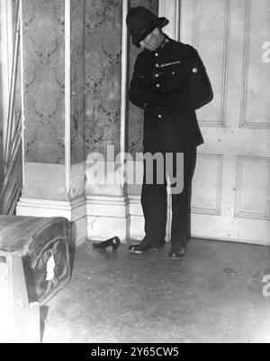 Le corps d'une veuve de 89 ans , Mme Minnie Freeman-Lee , a été retrouvé coincé dans un coffre lorsque la police a pénétré de force dans sa maison de 22 pièces Winford , Ray Park Avenue , Maidenhead , Berks . On pense que Mme Lee est morte le week-end dernier . La découverte whave a été collectée . La maison avait été saccagée et les agents du CID avaient recueilli les déclarations de plusieurs personnes pour établir si Mme Lee possédait ou non , comme on le lui disait , une grande quantité de bijoux . Photo montre : un policier vu regardant le coffre dans le hall de la maison de Mme Lee peu après la découverte de son corps en treillis. 2n Banque D'Images