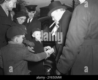 Winnie fait une tournée le jour des élections dans sa circonscription M. Winston Churchill a fait une tournée le jour des élections dans sa circonscription , Woodford , dans une voiture qui faisait escale dans les bureaux de vote et faisait du démarchage de dernière minute . Au cours de sa tournée, M. Churchill rencontre et serre la main à quelques écoliers. 23 février 1950 Banque D'Images