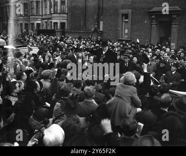 M. Churchill fait la tournée électorale de Hammersmith M. Winston Churchill a visité aujourd'hui la plupart des rues de Hammersmith et s'est adressé à des réunions en plein air au nom du candidat conservateur, Anthony Fell , qui se présente aux élections par dans la circonscription de South Hammersmith . Son adversaire est M. Tom Williams , travailliste . M. Churchill a d'abord appelé au club constitutionnel de Hammersmith , d'où il a commencé sa tournée du district dans une voiture à ciel ouvert M. Churchill donne son fameux signe V à la foule enthousiaste après avoir parlé de la voiture ouverte lors de sa tournée de South Hammersmith c Banque D'Images