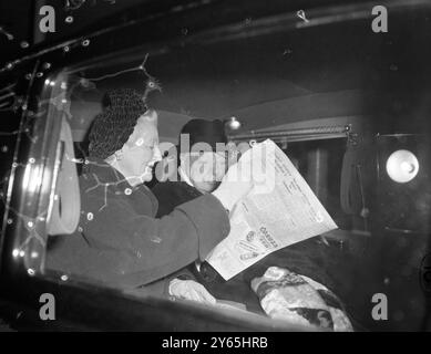 Sir Winston de retour de Paris Lady Churchill montre à Sir Winston le journal du soir alors qu'ils sont assis dans leur voiture les ramenant de l'aéroport de Londres à leur retour de Paris. 6 novembre 1958 Banque D'Images