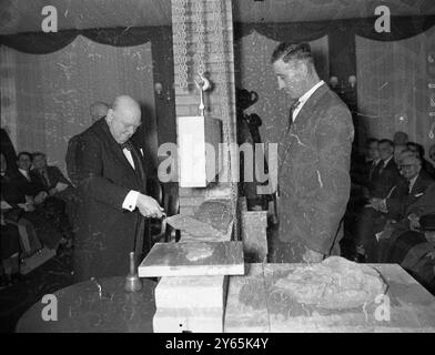 Churchill pose une nouvelle pierre. Sir Winston Churchill , ancien premier ministre , se concentre alors qu'il pose la première pierre des nouveaux bureaux londoniens de Cassels the Publishers , à Red Lion Square , Londres . 23 avril 1956 Banque D'Images