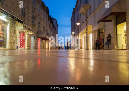 Carreaux de sol brillants photographiés sous un angle bas sur Marmontova Ulica, une rue commerçante principale / route piétonne pour les acheteurs piétons / shopping & visiteurs touristiques, et la population locale. Diviser. Croatie. (138) Banque D'Images