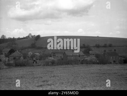 Les villageois d’Imber attendent depuis 1943 la permission de rentrer chez eux, mais ils savent maintenant que leur magnifique Domesday Village restera à jamais déserté au centre d’une école de combat militaire. La photo montre une partie du village d'Imber vue de la montée du sol qui surplombe la vallée dans laquelle il se niche. Des fenêtres sans verre, des jardins envahis par la végétation et un manque d'activité humaine constituent la scène de la désolation silencieuse du 6 avril 1948 Banque D'Images