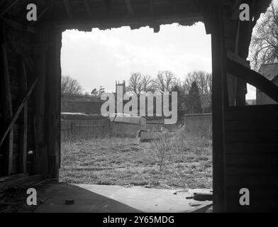 Les villageois d’Imber attendent depuis 1943 la permission de rentrer chez eux, mais ils savent maintenant que leur magnifique Domesday Village restera à jamais déserté au centre d’une école de combat militaire. Des spectacles de photos encadrés dans la porte d'une grange en ruine, des bâtiments agricoles négligés sont vus avec la tour de l'église Imber s'élevant en arrière-plan. 6 avril 1948 Banque D'Images