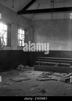 Les villageois d’Imber attendent depuis 1943 la permission de rentrer chez eux, mais ils savent maintenant que leur magnifique Domesday Village restera à jamais déserté au centre d’une école de combat militaire. La photo montre que la salle d'école du village est parsemée de formes brisées. la cloche qui convoquait les enfants du village à leurs leçons a encore sa corde suspendue dans le coin de la salle de classe. 6 avril 1948 Banque D'Images