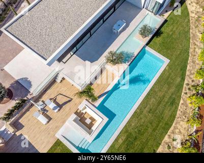 Image aérienne capturant une luxueuse villa méditerranéenne, avec une piscine élégante, un jardin bien entretenu et une architecture moderne entourée d'une végétation luxuriante Banque D'Images