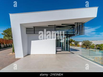 Une vue exquise sur une villa méditerranéenne de luxe présentant une architecture moderne et élégante avec des couleurs blanches dominantes, de grandes fenêtres en verre et innovativ Banque D'Images