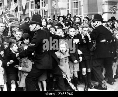 14 octobre 1938 des foules d'enfants, retenues par des policiers, acclament la reine Mary où elle ouvre une nouvelle extension à l'hôtel de ville de Lambeth à Brixton, Londres. Banque D'Images