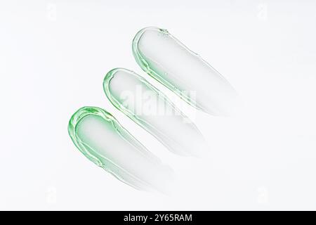 Frottis transparents de gel d'aloès teinté vert, parfait pour les soins du visage et du corps, isolés sur un fond blanc pour mettre en valeur la texture et la viscosité Banque D'Images