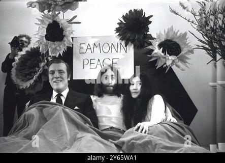 Le concours de télévision Eamonn Andrews est assis dans un lit avec John Lennon et Yoko Ono pendant le programme télévisé Thames «Today». Le couple wer interviewe Eamonn sur le programme . John et Yoko sont rentrés à Londres d'Amsterdam , où ils ont dormi pendant une semaine à l'hôtel Hilton , pour protester contre la violence dans le monde . Aujourd'hui , ils ont annoncé qu'ils envoyaient aux dirigeants du monde un gland chacun pour planter pour la paix le 1er avril 1969 Banque D'Images