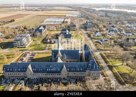 Une prise de vue aérienne capturant un mélange de structures résidentielles modernes et traditionnelles dans un quartier de banlieue avec des routes et des espaces verts. Banque D'Images