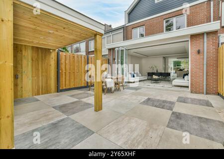 Un patio moderne se transforme en un espace de vie décloisonné, mettant en valeur un mélange de vie intérieure et extérieure. Banque D'Images