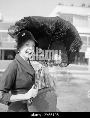 Un parasol noir garni de dentelle noire et âgé d'environ 150 ans qu'elle a trouvé dans le célèbre marché aux puces de Paris est porté par l'actrice hollywoodienne June Havoc à l'aéroport de Londres .à son retour de France. 23 septembre 1956 Banque D'Images