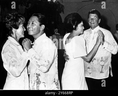 Le président des Philippines Ferdinand E Marcos et Mme Nancy Reagan ( à gauche ) , épouse du gouverneur californien Ronald Reagan , et l'épouse du président Imelda Marcos , et M. Reagan (à droite), dansent ensemble lors d'un cocktail au Palais présidentiel le 9 septembre 1969 . Le cocktail , suivi d'un dîner , a été donné par le Président en l'honneur du Gouverneur en visite et de son épouse , qui se rendent à Manille pour assister à une cérémonie inaugurale du Centre culturel le .18 septembre 1969 Banque D'Images