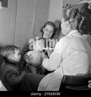 Clinique mobile du conseil du comté de Middlesex. Un médecin examine un bébé avec une spatule janvier 1954 Banque D'Images