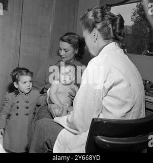 Clinique mobile du conseil du comté de Middlesex. Baby sitting des genoux de la mère examiné par un médecin janvier 1954 Banque D'Images