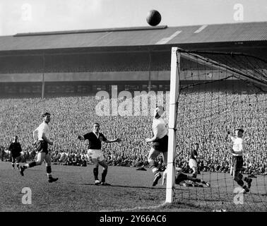 Écosse - Angleterre les défenseurs de l'Angleterre sont anxieux, mais ce tir de l'Écosse à l'extérieur de la gauche, Weir, est passé juste en dehors du but dans le match à Hampden Park. Le gardien de but est Ron Springett et le saut est arrière gauche, Wilson. À gauche se trouve la moitié centrale de l'Angleterre Bill Slater (chemise blanche). 9 avril 1960 Banque D'Images