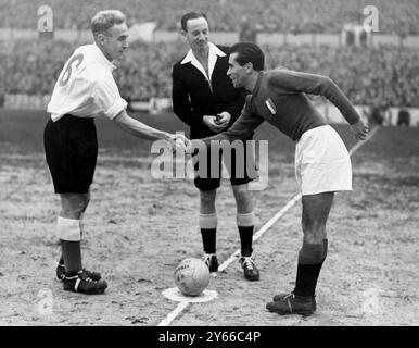 Angleterre v Italie Billy Wright de Wolverhampton Wanderers (à gauche), capitaine de l'Angleterre, et Carapellese (Turin), capitaine de l'Italie serrant la main avant le coup d'envoi de l'international à White Hart Lane. Le Centre est l'arbitre, J A Mowatt (Écosse). L'Angleterre a gagné le match 2-0. 30 novembre 1949 Banque D'Images