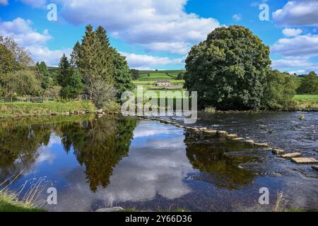 Burnsall L'un des plus beaux villages de Wharfedale, Burnsall se trouve sur un virage de la rivière Wharfe entouré par un cercle spectaculaire de fesses. Banque D'Images