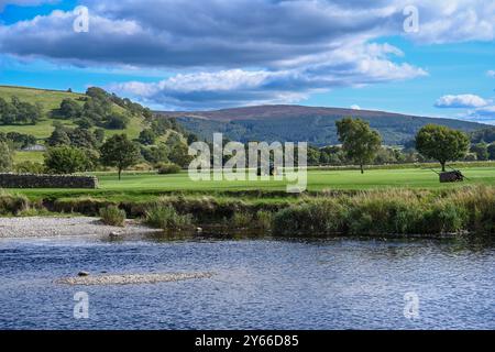 Burnsall L'un des plus beaux villages de Wharfedale, Burnsall se trouve sur un virage de la rivière Wharfe entouré par un cercle spectaculaire de fesses. Banque D'Images