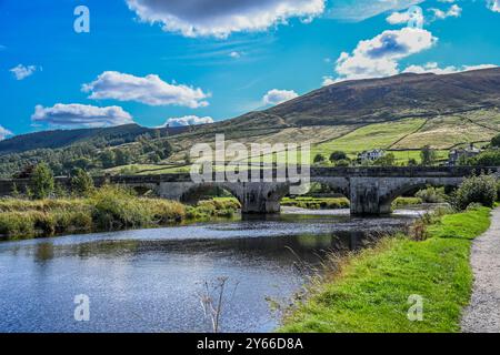 Burnsall Bridge un des plus beaux villages de Wharfedale, Burnsall se trouve sur un virage de la rivière Wharfe entouré par un cercle spectaculaire de F. Banque D'Images