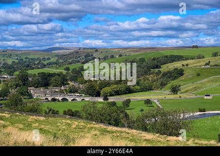 Burnsall L'un des plus beaux villages de Wharfedale, Burnsall se trouve sur un virage de la rivière Wharfe entouré par un cercle spectaculaire de fesses. Banque D'Images