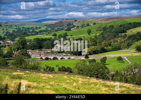 Burnsall L'un des plus beaux villages de Wharfedale, Burnsall se trouve sur un virage de la rivière Wharfe entouré par un cercle spectaculaire de fesses. Banque D'Images