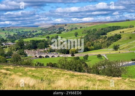 Burnsall L'un des plus beaux villages de Wharfedale, Burnsall se trouve sur un virage de la rivière Wharfe entouré par un cercle spectaculaire de fesses. Banque D'Images